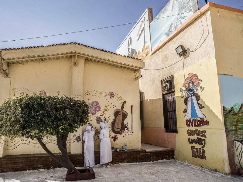 This picture taken during a government-guided tour on December 27, 2020 shows inmates drawing a mural on a wall at al-Qanatir women's prison, at the tip of the Nile delta in Qalyoubiya province, about 30 kilometres north of Egypt's capital. Khaled DESOUKI / AFP