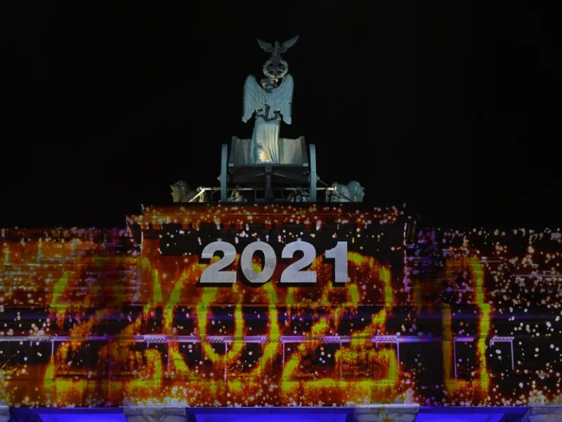 Berlin's landmark Brandenburg Gate is illuminated with the lettering '2021' at the start of a concert 'Willkommen 2021' (Welcome 2021) on New Year's Eve, December 31, 2020. This year's show at the Brandenburg Gate will take place without the traditional fireworks due to restrictions that apply during the current lockdown to curb the spread of the coronavirus (Covid-19) pandemic. John MACDOUGALL / AFP / POOL