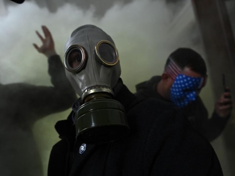 A supporter of US President Donald Trump wears a gas mask as he protests after storming the US Capitol on January 6, 2021, in Washington, DC. Demonstrators breeched security and entered the Capitol as Congress debated the a 2020 presidential election Electoral Vote Certification. President-elect Joe Biden denounced the storming of the US Capitol as an "insurrection" and demanded President Donald Trump go on television to call an end to the violent "siege." Brendan SMIALOWSKI / AFP