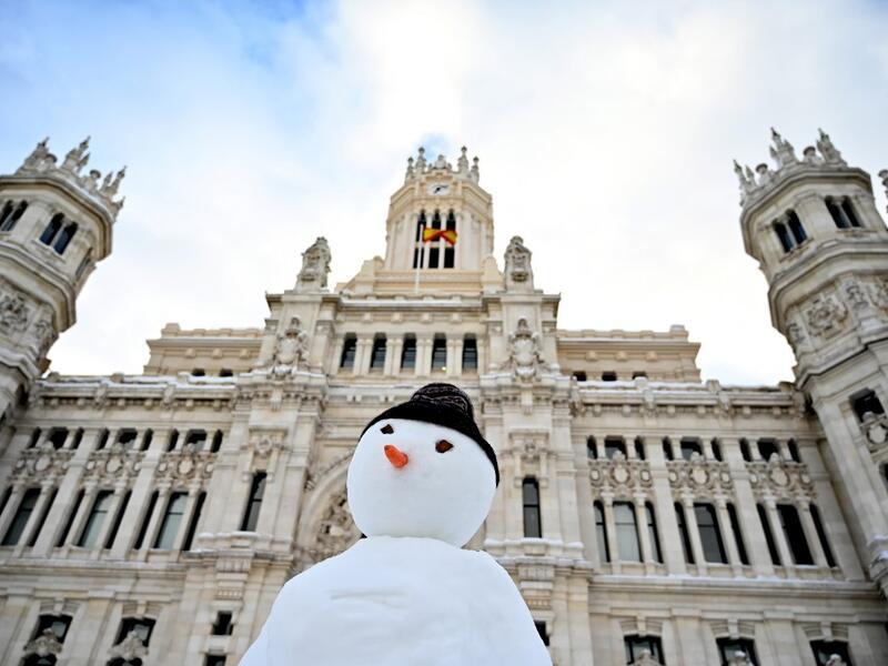 A snowman is built outside the Cibeles Palace in Madrid on January 10, 2021. Snowstorms in Spain left three people dead and caused chaos across much of the country, trapping motorists and shutting down the capital's air and rail links. Gabriel BOUYS / AFP