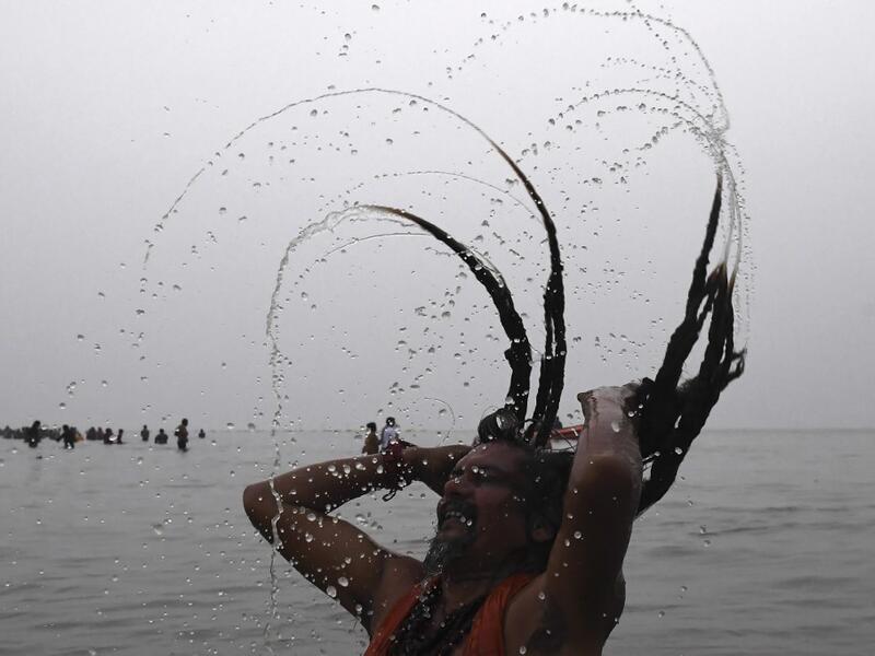 A Sadhu or a Hindu holyman takes a dip at the confluence of Ganges and the Bay of Bengal during the Gangasagar Mela on the occasion of Makar Sankranti, a day considered to be of great religious significance in Hindu mythology, at Sagar Island, around 150 kms south of Kolkata on January 14, 2021. Dibyangshu SARKAR / AFP