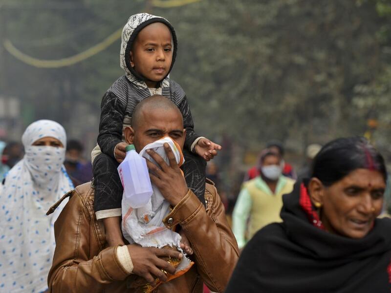 Hindu devotees arrive to take a holy dip at Sangam, the confluence of rivers Ganges, Yamuna and the mythical Saraswati, on the occasion of Makar Sankranti, a day considered to be of great religious significance in Hindu mythology, during the annual 'Magh Mela' festival in Allahabad on January 14, 2021. Sanjay KANOJIA / AFP