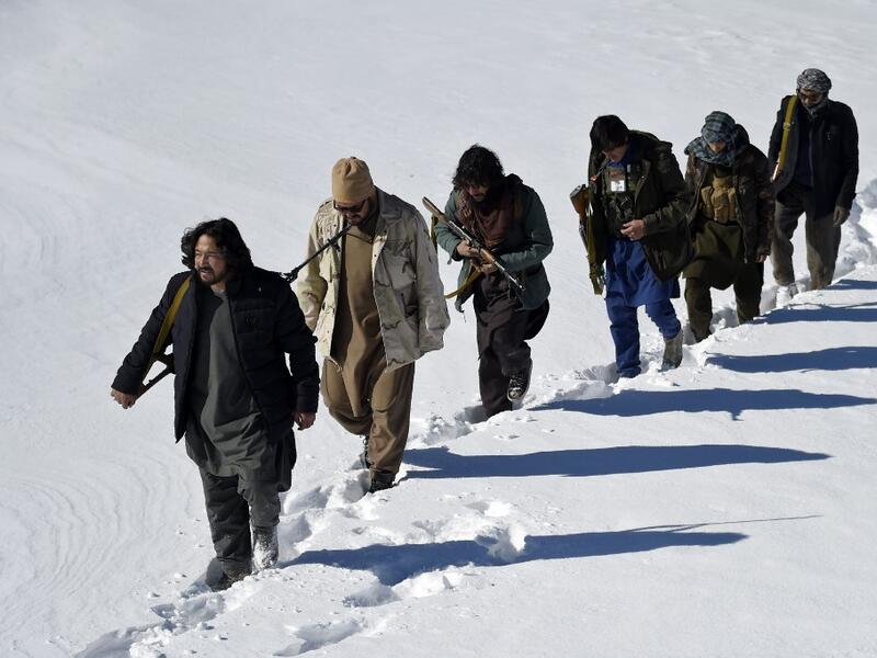 In this photo taken on January 9, 2021, Hazara armed militia for the Resistance for Justice Movement, walk on a snow-covered path during a patrol against Taliban insurgents at Hisa-e-Awali Behsud district of Maidan Wardak Province. Comprising roughly 10 to 20 percent of Afghanistan's 38-million population, Hazaras have long been persecuted for their largely Shiite faith by Sunni hardliners in a country wracked by deep ethnic divisions. WAKIL KOHSAR / AFP