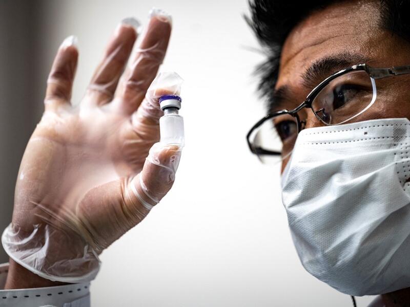 A medical personnel presents a containers with water, which are used to preserve the vaccinnes in a deep freezer during a Covid-19 coronavirus vaccination drill at the Kawasaki City College of Nursing in Kawasaki on January 27, 2021. Philip FONG / AFP
