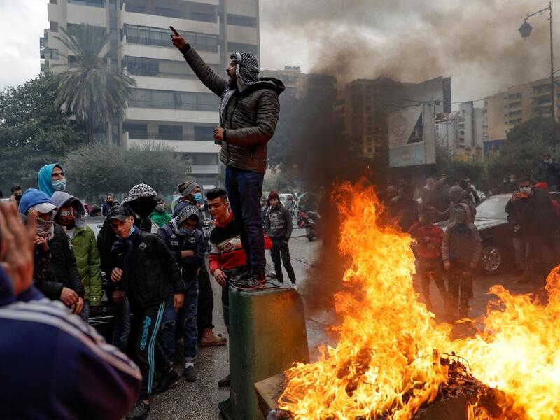 Lebanese anti-government protesters burn garbage as they go around the homes of deputies and government officials in the northern port city of Tripoli to protest the economic situation and their role in leading the country to crisis, on January 28, 2021. Tripoli was already one of Lebanon's poorest areas before the coronavirus pandemic piled new misery onto a chronic economic crisis. Many of its residents have been left without an income since Lebanon imposed a full lockdown earlier this month in a bid to s