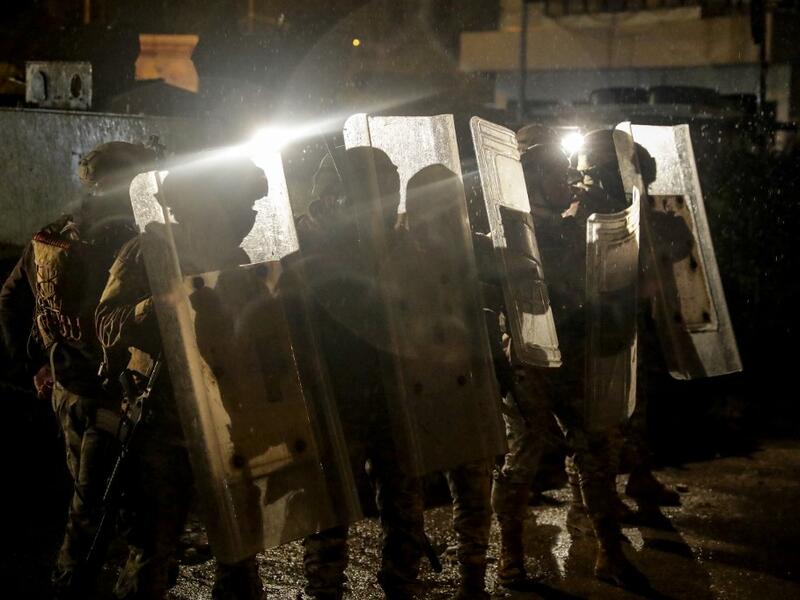 Lebanese security forces advance during clashes with anti-government protesters in the northern city of Tripoli, on January 29, 2021. More than 400 people have been wounded in northern Lebanon this week in clashes between security forces and protesters angered by a coronavirus lockdown they say is starving them. JOSEPH EID / AFP