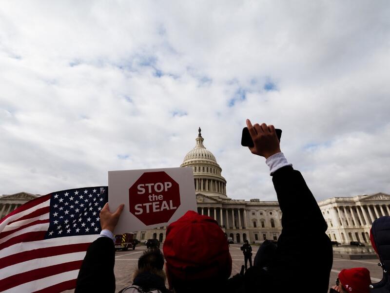 A man with a Stop the Steal sign stands in front of the U.S. Capitol Building on January 6, 2021 in Washington, DC. A pro-Trump mob stormed the Capitol earlier, breaking windows and clashing with police officers. Trump supporters gathered in the nation's capital to protest the ratification of President-elect Joe Biden's Electoral College victory over President Donald Trump in the 2020 election. Jon Cherry/Getty Images/AFP