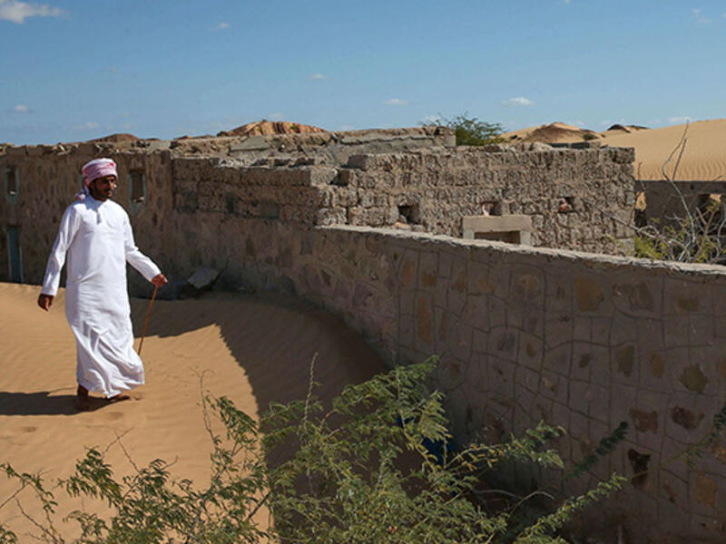 A former inhabitant of Wadi al-Murr, walks near an abandoned house in the Omani village, about 400 kms south-west of the capital Muscat. (AFP)
