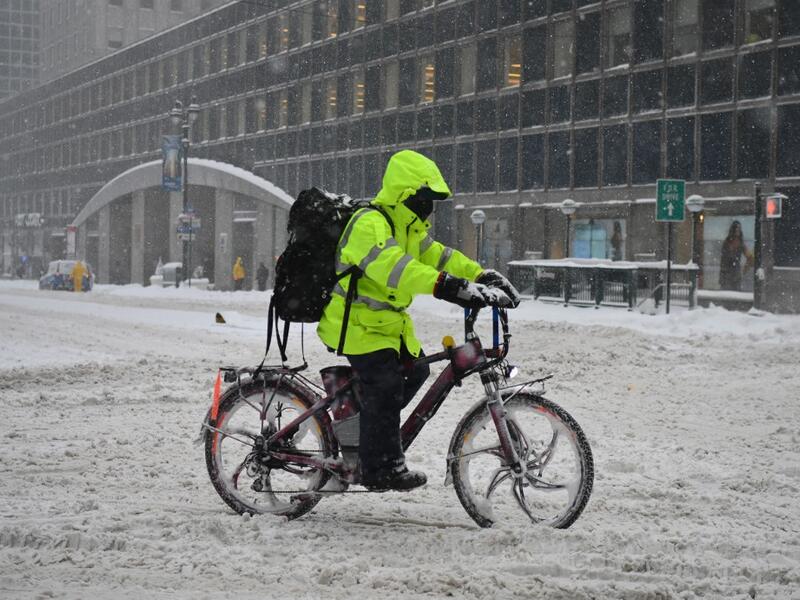 A person on a delivery bike rides during a winter storm on February 1, 2021 in New York City. A powerful winter storm is set to dump feet of snow along a stretch of the US east coast including New York City on February 1, 2021, after blanketing the nation's capital. The National Weather Service issued storm warnings from Virginia to Maine -- a swathe home to tens of millions of people -- and forecast snowfall of 18 to 24 inches (45-60 centimeters) in southern New York, northeastern New Jersey and parts of s