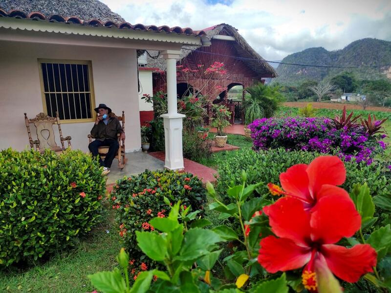 Eduardo Hernandez, owner of a private restaurant and a tobacco cultivator, smokes a cigar in his house in Vinales, Cuba, on January 28, 2021. At the foot of the majestic rock formations of Vinales, the terraces of the restaurants look empty and the lodgings have closed. With the arrival of COVID-19, the incipient prosperity of this Cuban town came to a halt and people abandoned tourism jobs to return to work the land. YAMIL LAGE / AFP