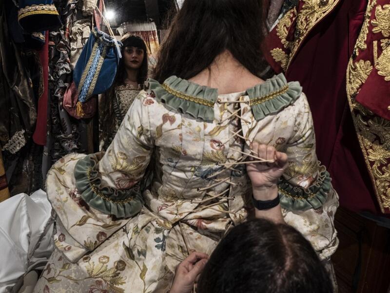 An employee (Front R) helps a reveller put on a traditional carnival costume in 'La Bauta' shop in Venice on February 6, 2021, as the traditional Venice carnival is being cancelled due to the Covid-19 pandemic. Marco Bertorello / AFP