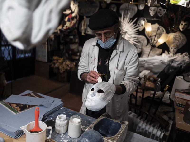 Mask artisan Hamid Seddighi works on a papier-mache mask in his laboratory 'Ca del Sol' in Venice on February 6, 2021, as the traditional Venice carnival is being cancelled due to the Covid-19 pandemic. Marco Bertorello / AFP