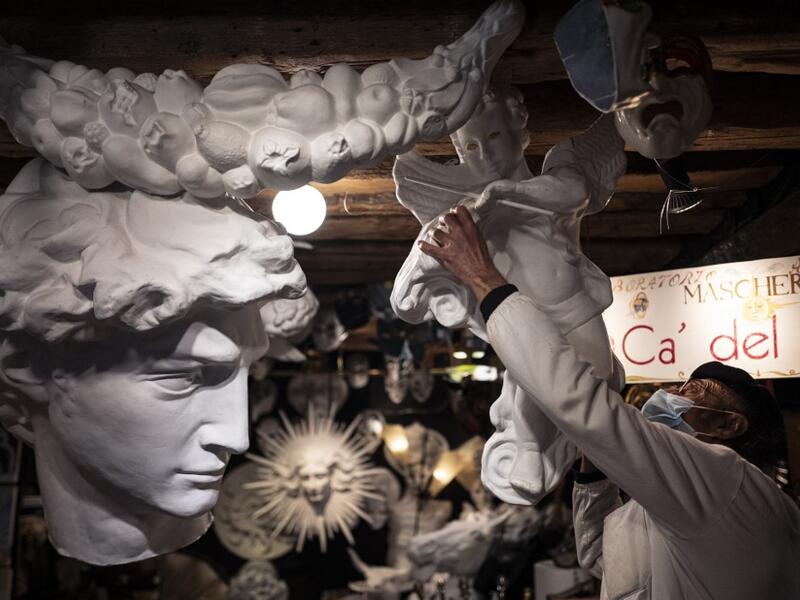 Mask artisan Hamid Seddighi adjusts a xreation in his laboratory 'Ca del Sol' in Venice on February 6, 2021, as the traditional Venice carnival is being cancelled due to the Covid-19 pandemic. Marco Bertorello / AFP