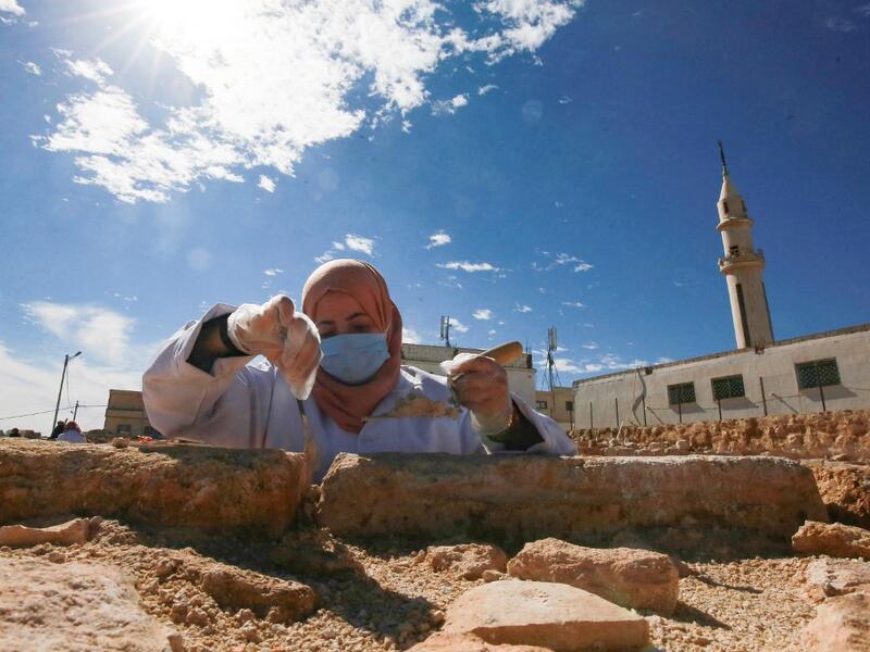 A worker employed by a pilot project run by the UN cultural agency UNESCO, restores a stone wall at an ancient church complex, in the small town of Rihab, some 70 kilometres north of the Jordanian capital Amman, on February 9, 2021. In the ruins of the ancient Byzantine church in Jordan, local townspeople and Syrian refugees work side by side on a project that unites preserving cultural heritage and fighting poverty.  Khalil MAZRAAWI / afp