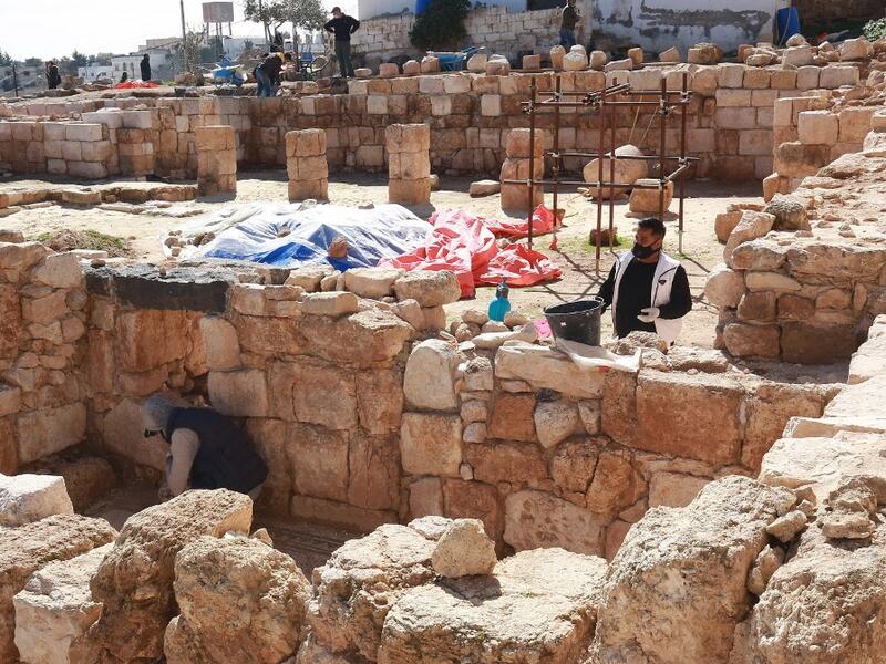 Workers employed by a pilot project run by the UN cultural agency UNESCO, restore a stone wall at an ancient church complex, in the small town of Rihab, some 70 kilometres north of the Jordanian capital Amman, on February 9, 2021. In the ruins of the ancient Byzantine church in Jordan, local townspeople and Syrian refugees work side by side on a project that unites preserving cultural heritage and fighting poverty.  Khalil MAZRAAWI / afp