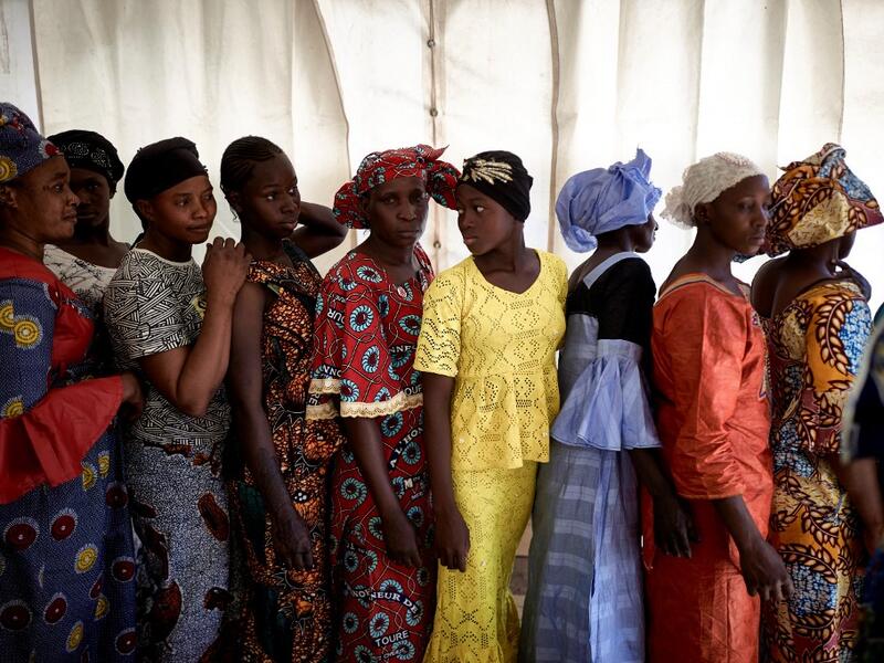 A group of gold miners queue in the backstage after having been selected by the Princess of Burundi, Esther Kamatari, to take part in a fashion show as part of the first edition of the International Gold Fair Afrik'Or, in Bamako, on February 12, 2021. The Princess of Burundi, selected 34 women among gold mines workers in southern Mali, to walk down the catwalk for a fashion show organised during the International Gold Fair. Gold represents 15% of Mali's exports and more than 20% of its GDP estimated at near