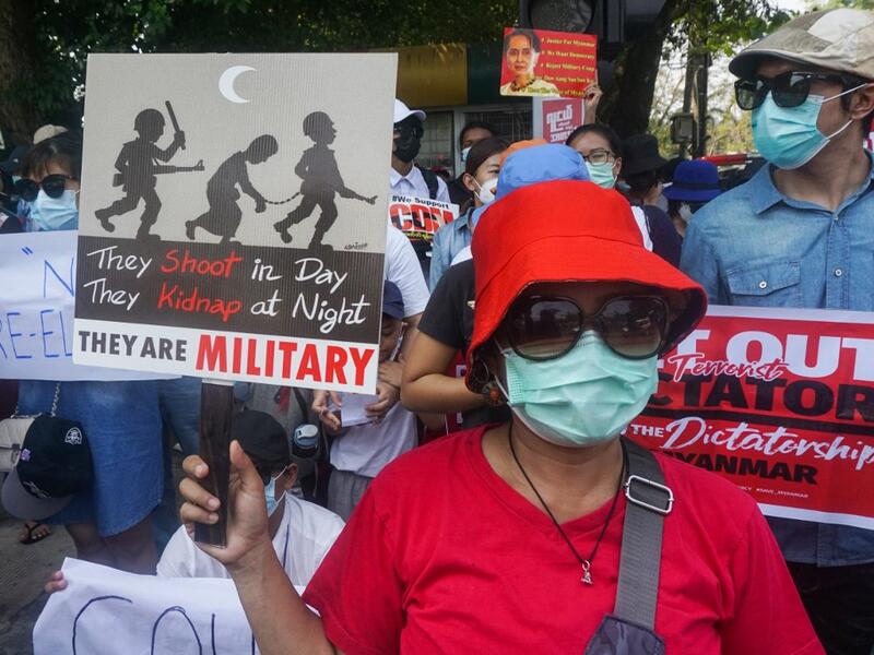 Protesters hold signs as they take part in a demonstration against the military coup in front of the Indonesian embassy in Yangon on February 23, 2021. Sai Aung Main / AFP