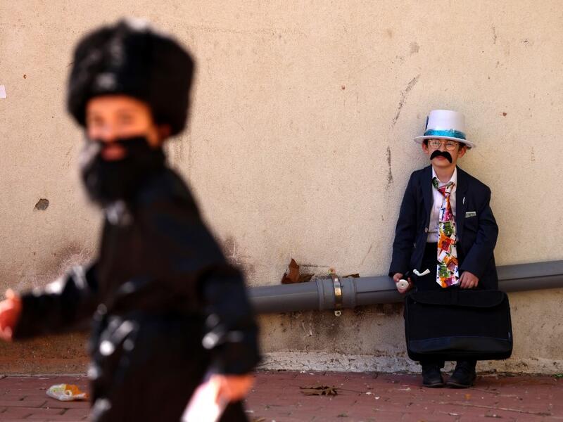 Israelis dressed in costumes in celebration of the Jewish holiday of Purim are pictured in the ultra-Orthodox neighborhood of Bnei Brak, on February 26, 2021. Israel imposed a night-time curfew for three nights from yesterday evening to curb the spread of the coronavirus during the Jewish holiday of Purim, the government said. The curfew, from 8:30 pm to 5:00 am daily (1830 GMT to 0300 GMT), will be in force from Thursday night until Sunday morning, a joint statement from the prime minister's office and the