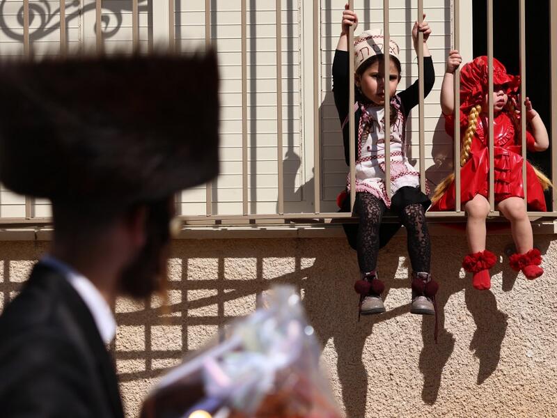 Israelis dressed in costumes in celebration of the Jewish holiday of Purim are pictured in the ultra-Orthodox neighborhood of Bnei Brak, on February 26, 2021. Israel imposed a night-time curfew for three nights from yesterday evening to curb the spread of the coronavirus during the Jewish holiday of Purim, the government said. The curfew, from 8:30 pm to 5:00 am daily (1830 GMT to 0300 GMT), will be in force from Thursday night until Sunday morning, a joint statement from the prime minister's office and the