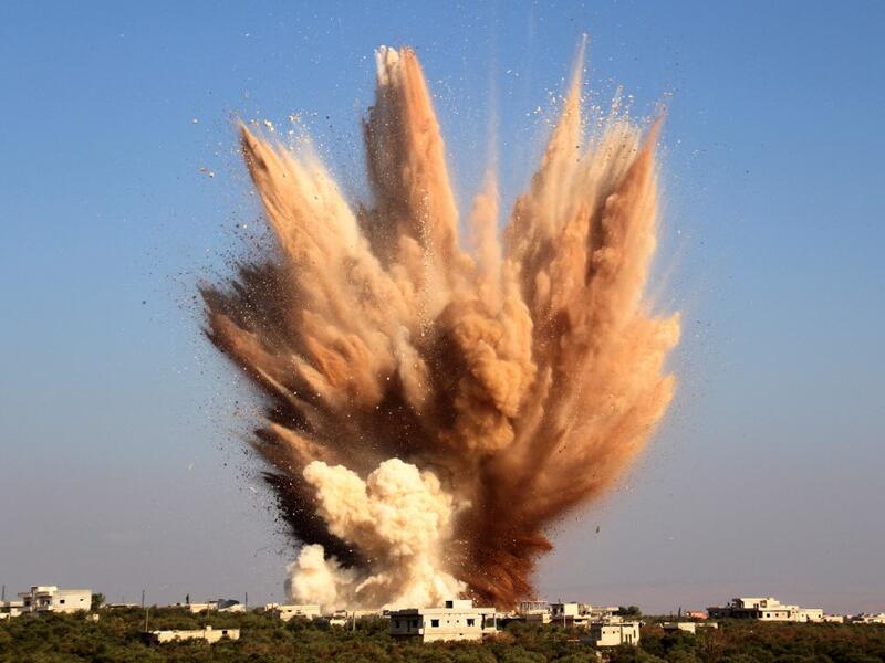 smoke billows above buildings following a reported attack on a tunnel 