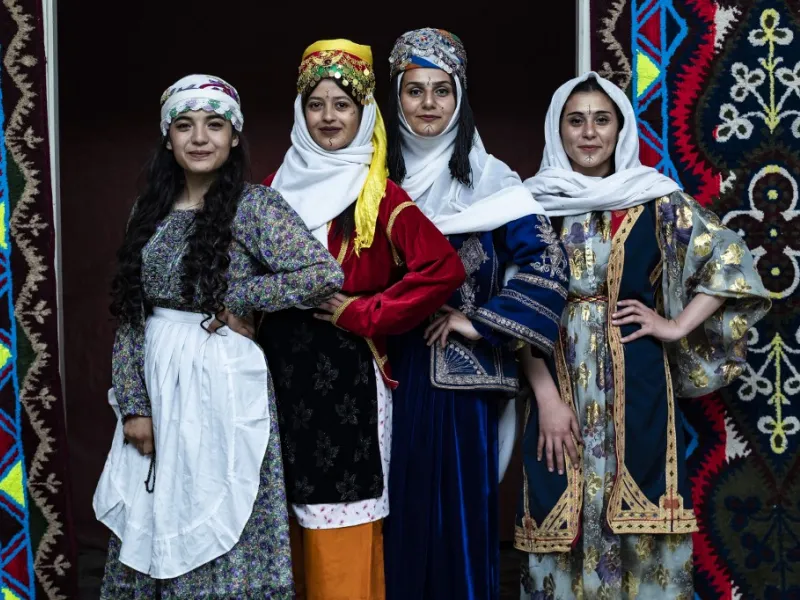 Syrian Kurdish women in traditional attire pose 