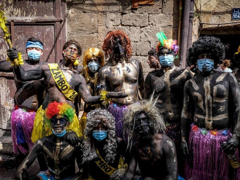 Carnival participants dressed in costume and wearing body paint pose for a group picture during the annual Zambo carnival held in Lebanon