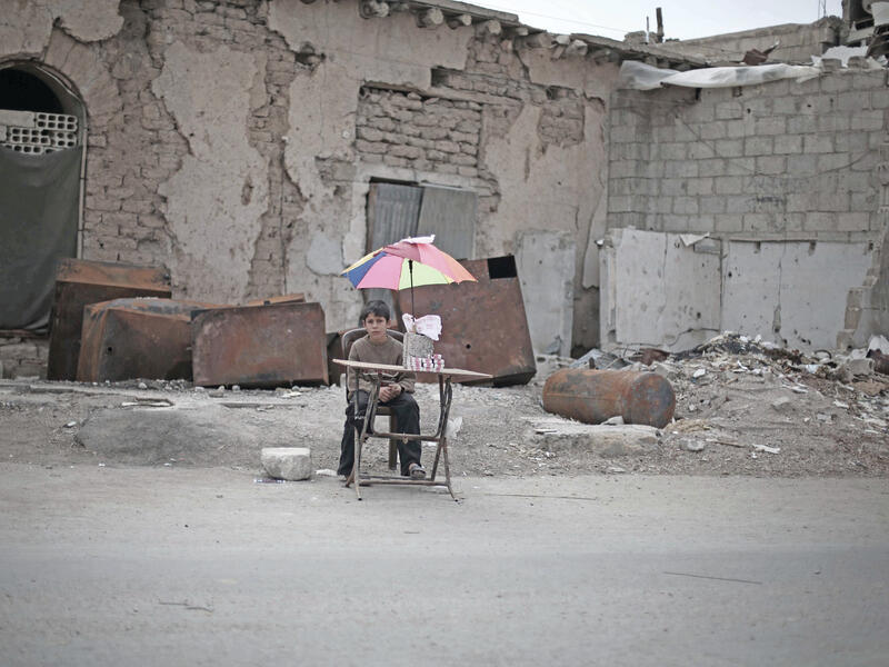 On 29 October 2015 in East Ghouta, rural Damascus, an internally displaced boy sits with items he will sell.