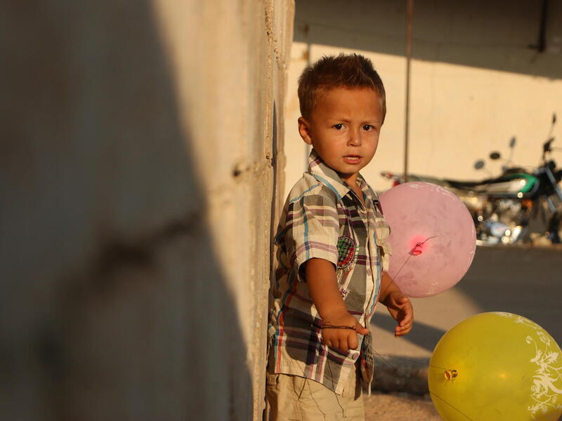 On 28 August 2018 in Idlib, Syrian Arab Republic, Ali, 3, stands near his temporary shelter. Ali was displaced with his family from northern rural Hama to Atma collective shelter near the Syrian-Turkish boarders.