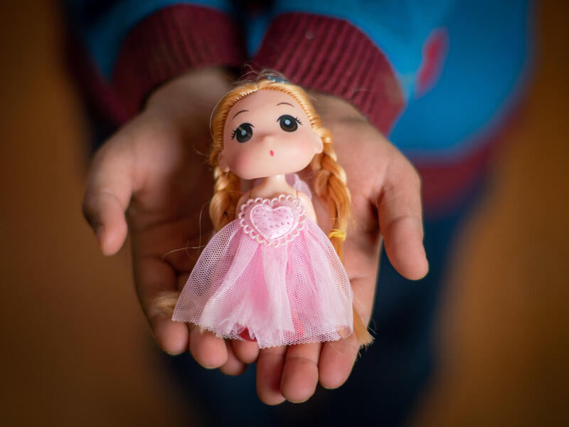 Yara, 10 years, holds a doll in Za’atari Refugee Camp.