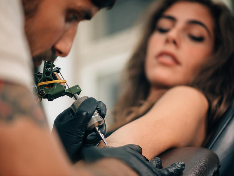 What is the Tattoo artist doing?