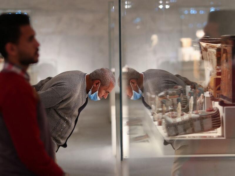 People look at displayed artifacts at Egypt's new National Museum of Egyptian Civilisation (NMEC)