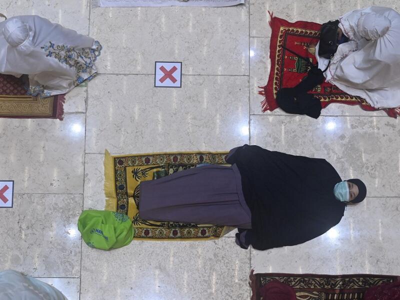 A woman rests prior to night prayers on the first day of Ramadan at the Istiqlal grand mosque in Jakarta