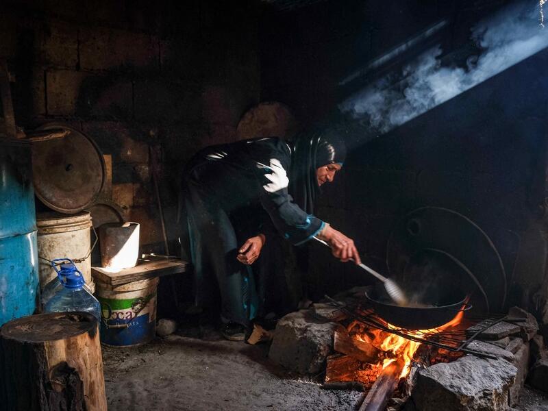 A woman fries potatoes as she prepares the fast-breaking "Iftar" meal