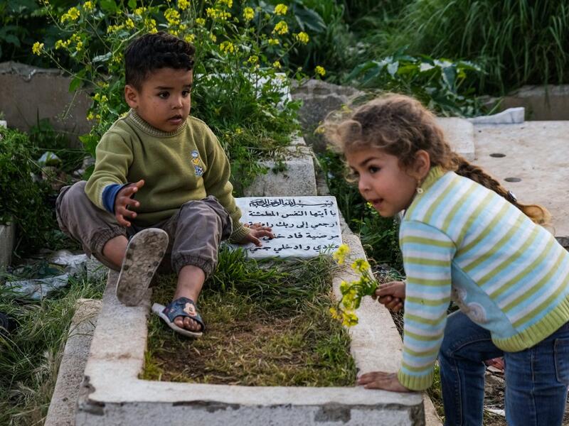 Children play by a grave in the Ghoraba (Strangers) cemetery