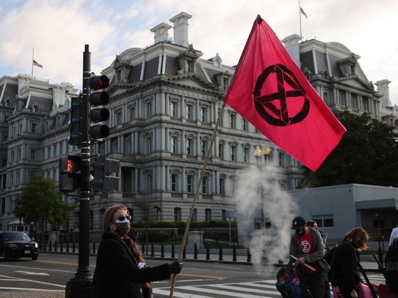 WASHINGTON, DC - APRIL 22: Activists halt traffic outside the White House while protesting against President Joe Biden's climate change policy on Earth Day, April 22, 2021 in Washington, DC. Organized by the Extinction Rebellion DC, protesters used bright pink wheelbarrows to dump heaps of cow manure at the intersection of New York Avenue and 17th Street NW on the west side of the White House campus. Despite the White House hosting a virtual Leaders Summit on Climate on Earth Day