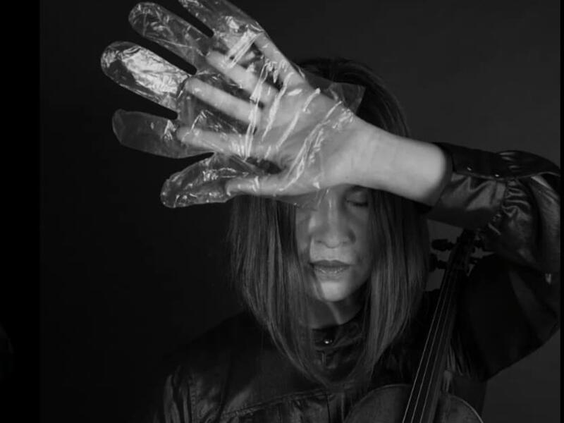 A musician in foil gloves is playing an instrument