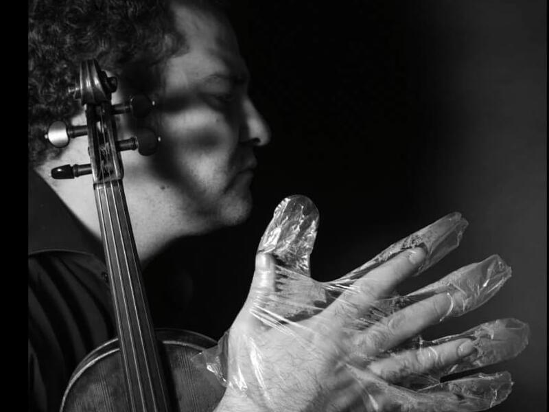 A musician in foil gloves is playing an instrument