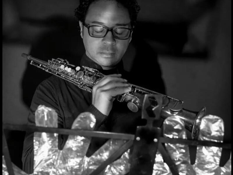 A musician in foil gloves is playing an instrument