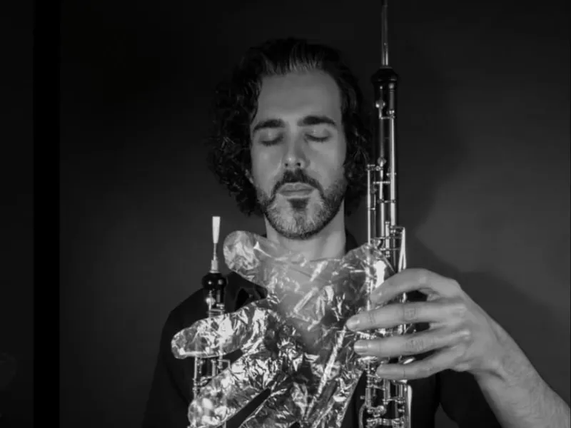 A musician in foil gloves is playing an instrument