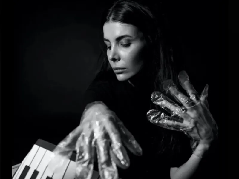 A musician in foil gloves is playing an instrument