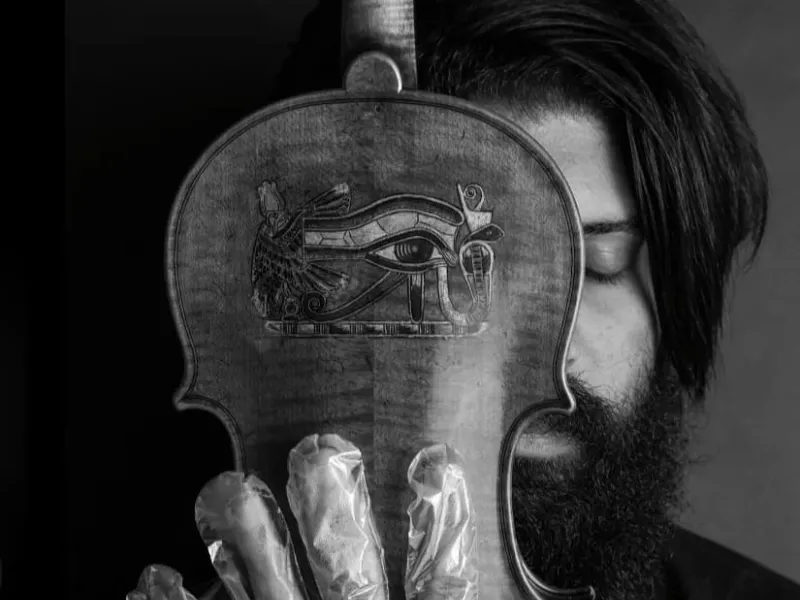 A musician in foil gloves is playing an instrument