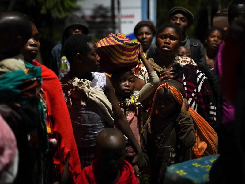 Congolese people carry their belongings as they flee from Goma, Democratic Republic of Congo (DRC), after the Nyiragongo volcano erupted, at the border point known as "Petite Barriere" in Gisenyi, Rwanda, on May 23, 2021. The government of the Democratic Republic of Congo has ordered the evacuation of the eastern city of Goma after the eruption of Mount Nyiragongo overlooking the border city. The lava reached the city's airport early Sunday, with an official from Virunga National Park 