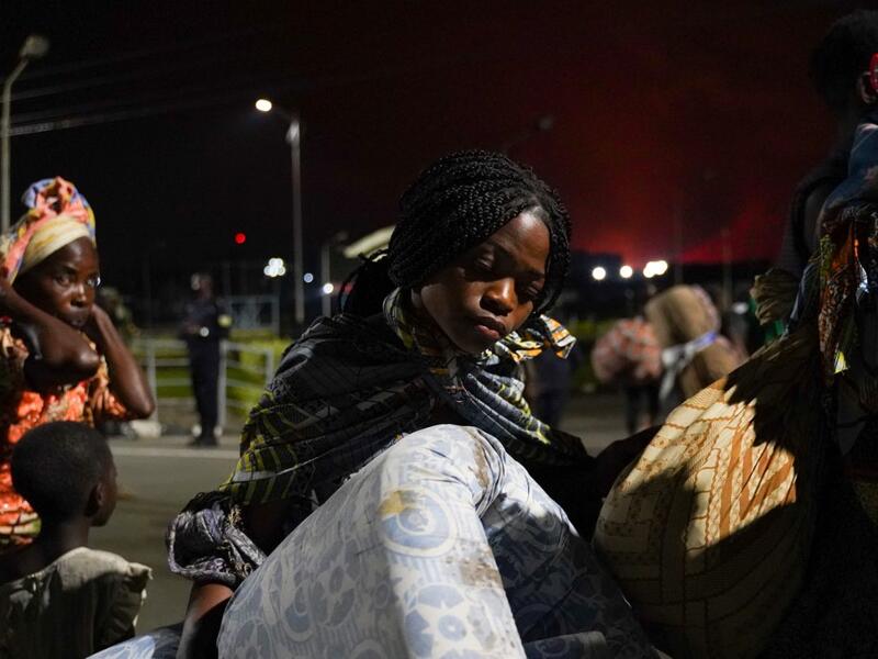 Congolese people carry their belongings as they flee from Goma, Democratic Republic of Congo (DRC), after the Nyiragongo volcano erupted, at the border point known as "Petite Barriere" in Gisenyi, Rwanda, on May 23, 2021. The government of the Democratic Republic of Congo has ordered the evacuation of the eastern city of Goma after the eruption of Mount Nyiragongo overlooking the border city. The lava reached the city's airport early Sunday, with an official from Virunga National Park 