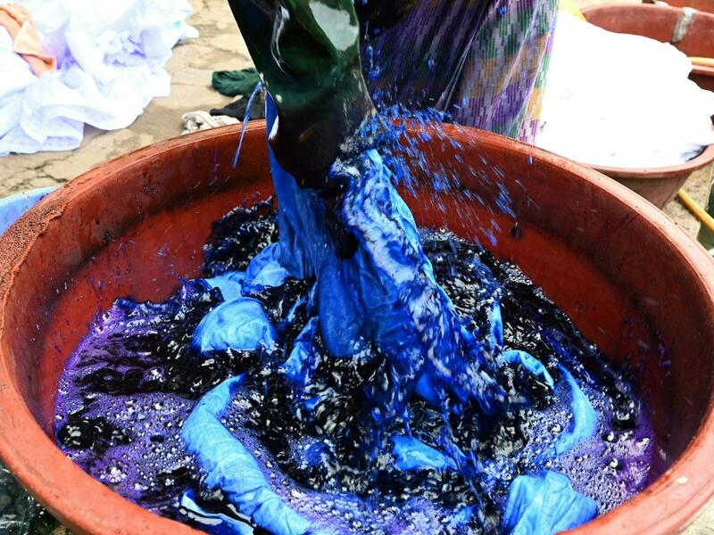 Dyers dye cotton fabric at Pathe'O house in the popular district of Treichville in Abidjan on March 31, 2021. A small self-taught tailor in his early years, the Ivorian-Burkinabe Pathe'O became the designer of African heads of state and celebrates the fiftieth anniversary of his brand, leading the "fight" for the recognition of fashion on the continent