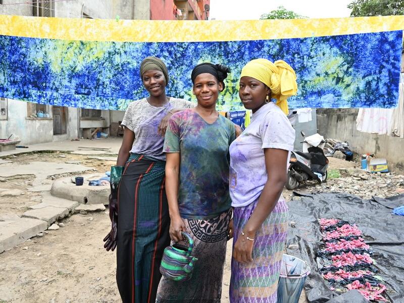 Dyers pose for a photograph at Pathe'O house in the popular district of Treichville in Abidjan on March 31, 2021. A small self-taught tailor in his early years, the Ivorian-Burkinabe Pathe'O became the designer of African heads of state and celebrates the fiftieth anniversary of his brand, leading the "fight" for the recognition of fashion on the continent