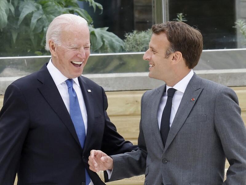 US President Joe Biden (L) and France's President Emmanuel Macron share a light moment before the family photo at the start of the G7 summit in Carbis Bay, Cornwall on June 11, 2021. G7 leaders from Canada, France, Germany, Italy, Japan, the UK and the United States meet this weekend for the first time in nearly two years, for three-day talks in Carbis Bay, Cornwall