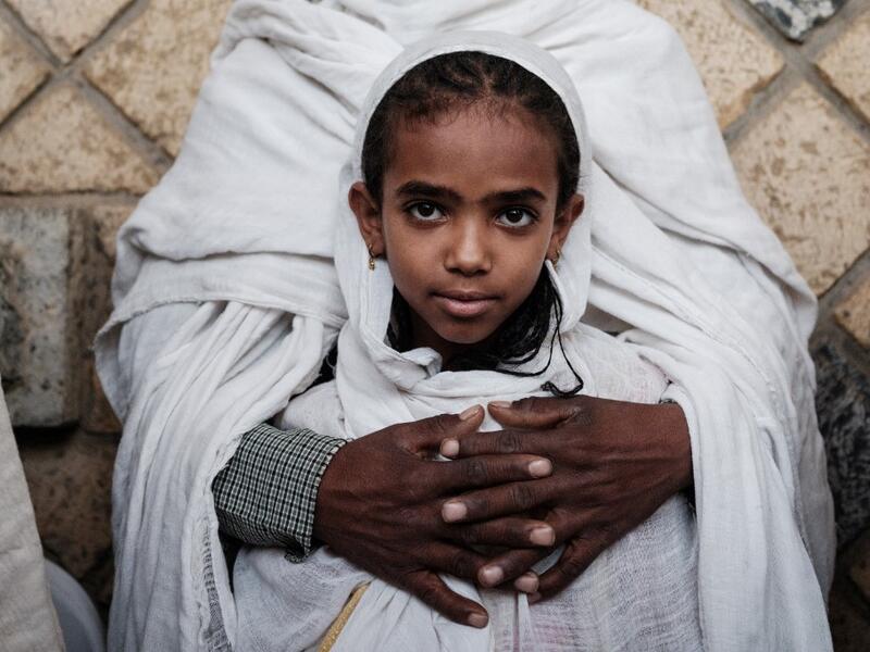 An 8-year-old girl Ethiopian Orthodox devote is held by her father as they attend the Saint Michael's anniversary celebration at St. Michael church in Mekele, the capital of Tigray region, Ethiopia