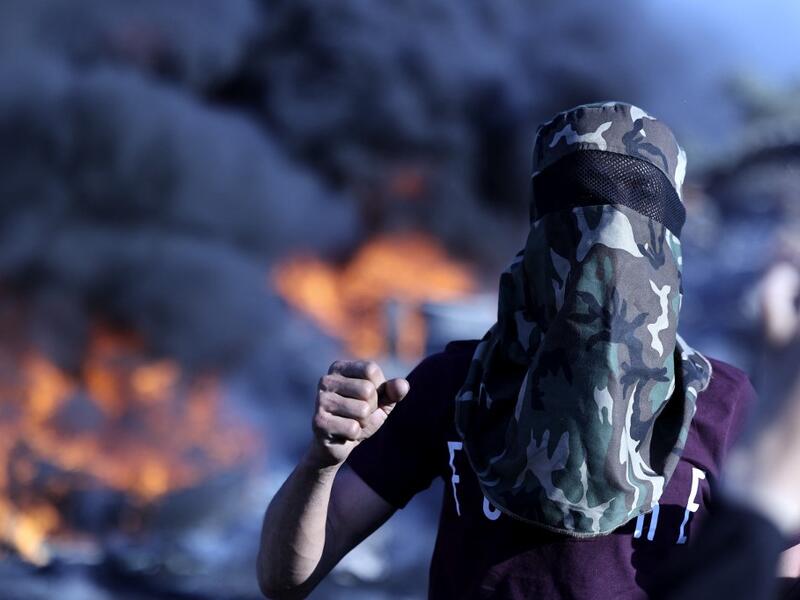 Palestinians burn tires during a night demonstration the expansion of the Jewish settlement outpost of Eviatar on the lands of Beita village, near the occupied West Bank city of Nablus