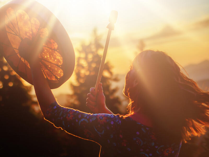 girl playing on shaman frame drum 