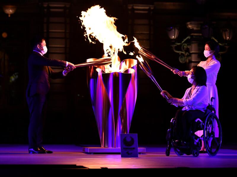 Tokyo 2020 Torch Relay Official Ambassadors Tadahiro Nomura (L), Aki Taguchi (2nd R), Satomi Ishihara (R) take part in the Paralympic Flame Lighting Ceremony at the State Guest House Akasaka Palace in Tokyo on August 20, 2021.